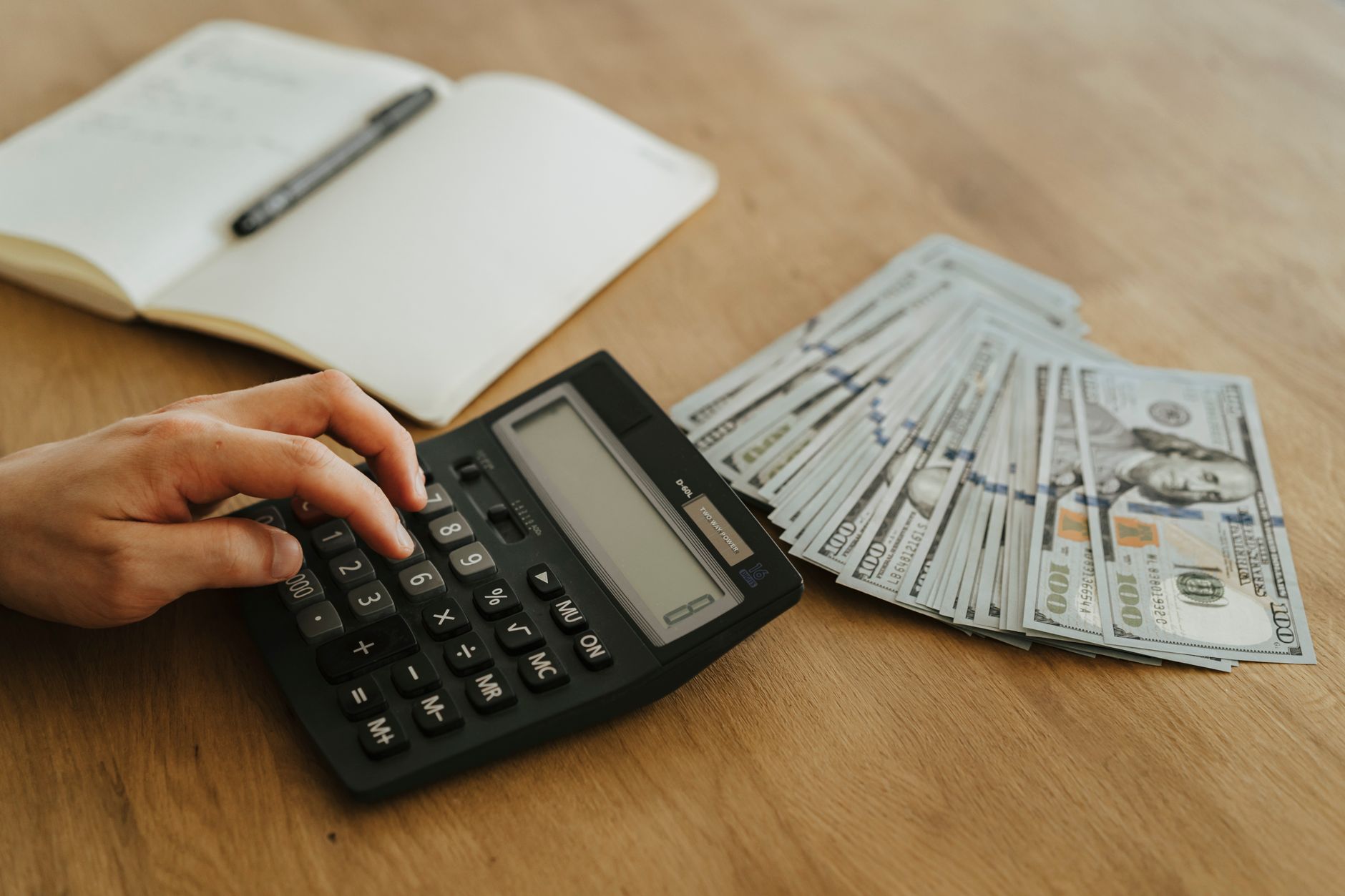 a person holding black desk calculator